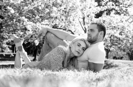 Photo for Young married people in love enjoying the spring beautiful nature. Beautiful young couple enjoying flowering garden. Man and woman dates, valentines and tenderness - Royalty Free Image