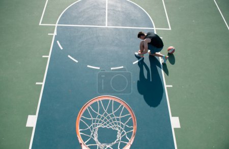 Téléchargez les photos : Joueur de basket-ball avec ballon sur le terrain extérieur - en image libre de droit