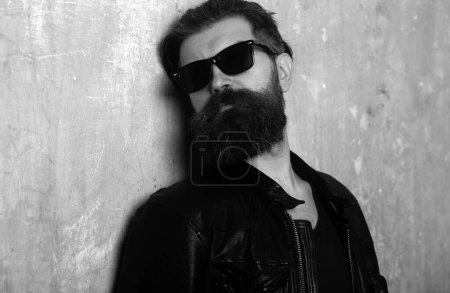 Téléchargez les photos : Portrait d'un bel homme. Hipster barbu sur fond mural beige - en image libre de droit