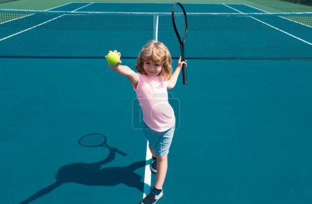 Téléchargez les photos : Enfant garçon jouant au tennis sur le terrain extérieur. Petite fille avec raquette de tennis et ballon dans un club de sport. Exercice actif pour les enfants. Activités estivales pour les enfants. Formation pour les jeunes enfants - en image libre de droit