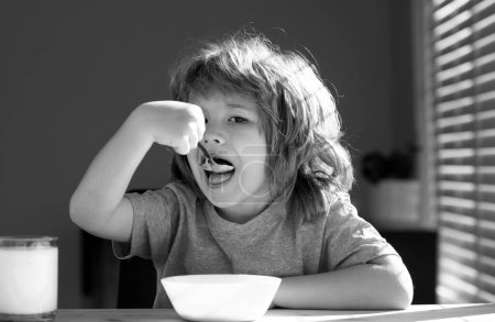 Photo for Child eating healthy food at home. Baby eat soup with spoon - Royalty Free Image