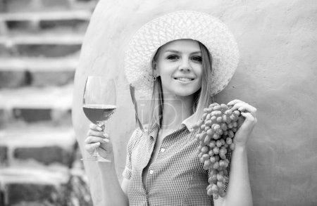 Téléchargez les photos : Jeune femme souriante dégustation de vin ou de jus de raisin. Vin fait à la main à partir de raisins blancs - en image libre de droit