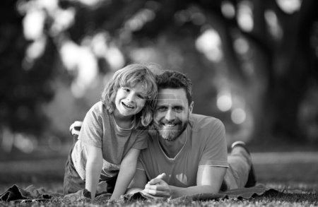 Téléchargez les photos : Père et fils souriant sur fond d'été brouillé au parc - en image libre de droit