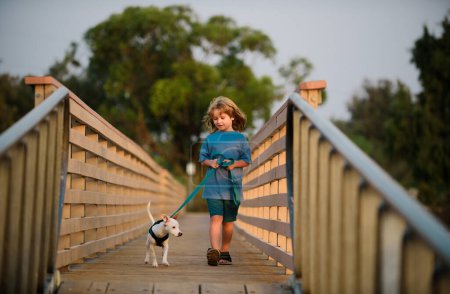 Foto de Juguemos juntos. Niño paseo con cachorro - Imagen libre de derechos