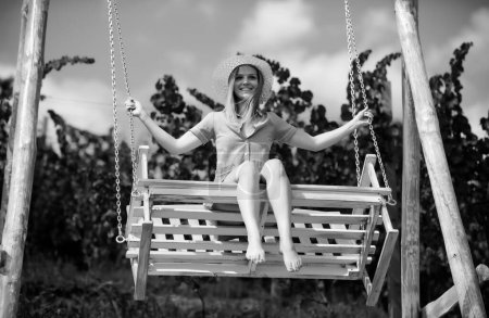 Téléchargez les photos : Portrait extérieur d'une jeune fille souriante et heureuse. Femme sensuelle balançant sur swing sur la nature d'été, jeune fille sexy se détendre dans le parc de printemps en plein air - en image libre de droit