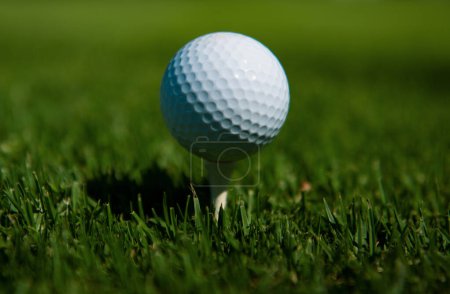 Photo for Golf ball in grass. Golf ball is on tee on green grass background - Royalty Free Image