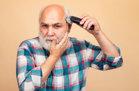 Porträt eines älteren Mannes, der im Friseursalon mit einer professionellen elektrischen Haarschneidemaschine getrimmt wird, Haarschnitt mit einem Rasiermesser