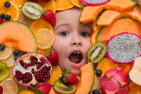 Téléchargez les photos : Frutit and child face close up. Top view of child face with mix fruit. Fruits set near kids face - en image libre de droit