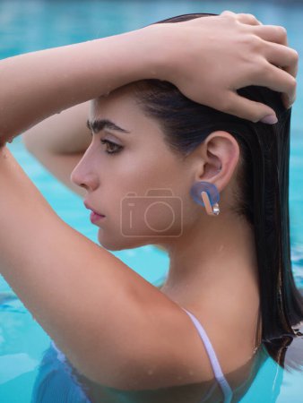 Photo for Beauty and body care. Sensual young woman in spa swimming pool. Sexy woman in the swimming pool. Summer portrait of woman in a swimming pool in summer. Young girl in a swimsuit swimming in the pool - Royalty Free Image