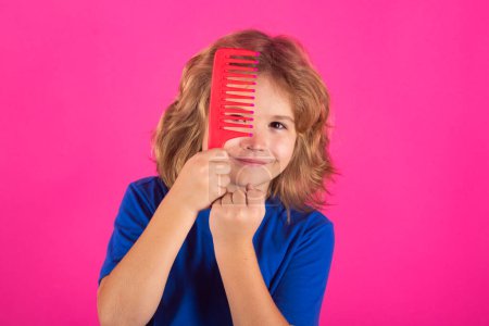 Photo for Child combing hair after shower. Child with a comb and problem hair. Kids shampoo. Hair does not comb without a conditioner balm - Royalty Free Image