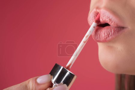 Close up woman applying red lipstick on lips. Sexy girl applied lipstick. Red lips lipstick make up. Putting lipstick on lips