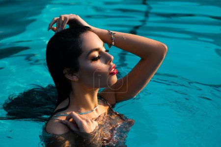 Foto de Retrato de verano de mujer de belleza en piscina. Mujer sexy en la piscina. Verano hermosa mujer descanso en una piscina. Modelo chica nadar con anillo flotante en un traje de baño nadando en la piscina - Imagen libre de derechos