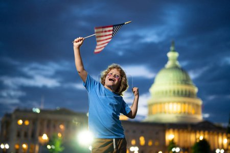 Téléchargez les photos : Enfant avec drapeau américain à Washington DC. Washington capitale des États-Unis. Les Américains célèbrent le 4 juillet. Le gamin tient le drapeau américain. Vague d'enfant Drapeau des États-Unis. L'Amérique célèbre le 4 juillet - en image libre de droit