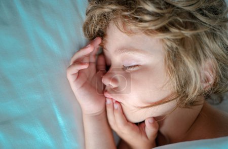 Photo for Concept of kids sleep. Child sleeping alone in comfortable bed with white linens - Royalty Free Image