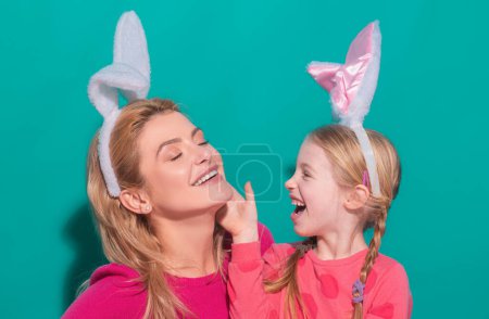 Téléchargez les photos : Bonne mère et fille enfant célébrant Pâques. Petite fille mignonne avec un visage drôle dans les oreilles de lapin rire, sourire et s'amuser - en image libre de droit