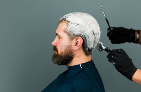 Photo for Bearded man color hair. Process of a man hair coloring at hairdresser salon - Royalty Free Image