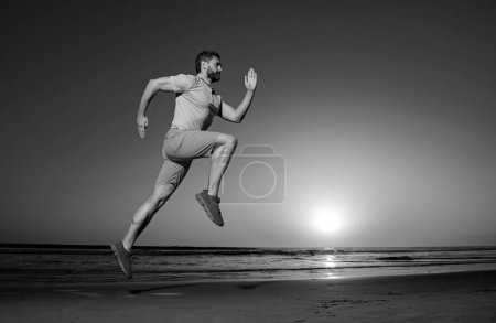 Téléchargez les photos : Jeune homme athlétique qui court. Concept de mode de vie sain. Mouvement de saut dynamique. Sport et mode de vie sain - en image libre de droit