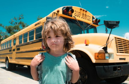 Foto de Triste chico frente a un autobús escolar. Concepto de escuela infantil. Educación. Educación en el hogar - Imagen libre de derechos
