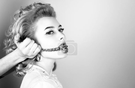 Foto de Pelirroja mujer de cerca retrato con cadena dorada en la boca - Imagen libre de derechos