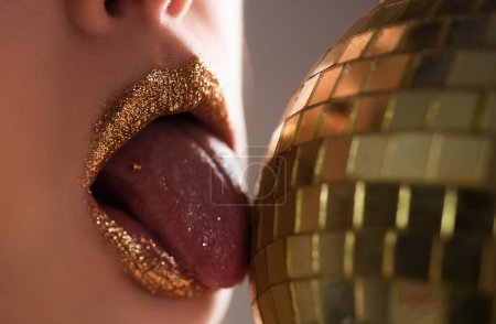 Foto de Sexy maquillaje de labios dorados. Moda seductora labio de metal dorado. Hermoso maquillaje - Imagen libre de derechos