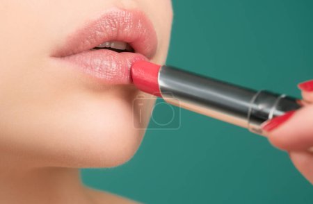 Téléchargez les photos : Concept beauté. Du rouge à lèvres à lèvres. Appliquer le maquillage des lèvres. choyer, concept de correction des lèvres - en image libre de droit