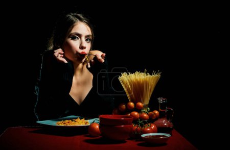 Photo for Hungry beautiful woman eat on noodles spaghetti on black background - Royalty Free Image