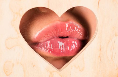 Photo for Lips in heart shape. Red lip with glossy lipgloss. Tongue and sexy. Close up, macro with beautiful mouths. Sexy kiss, sensual seductive lips of a young woman. Cosmetics and beauty salon - Royalty Free Image