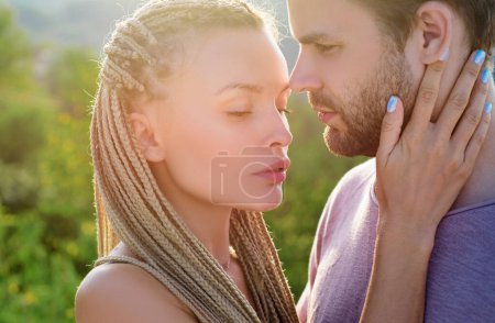 Romantic couple in love looking at each other and Kissing. Portrait of two sweet gentle delicate gorgeous attractive married people kissing outdoor