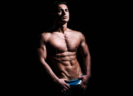 Photo for Sexy male bare torso. Strong, fit and sporty man over black background - Royalty Free Image