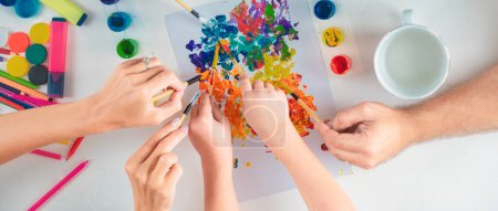 Foto de La mano de los humanos está dibujando con lápices de colores. Vista superior manos viejas y jóvenes con materiales de arte - Imagen libre de derechos