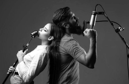 Photo for Boy and girl with excited faces enjoy music. Couple in recording studio. Music performance vocal. Singer singing song with a microphone - Royalty Free Image