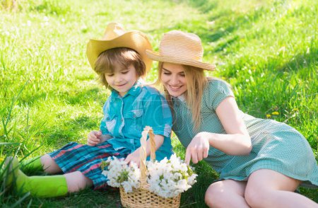 Cheerful gardener family sitting during a picnic in garden. Young smiling family relaxing at sunny day.