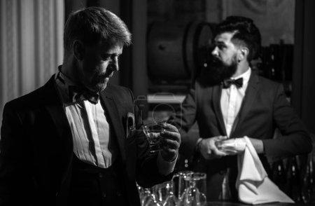Foto de Caballeros en el bar. Camarero. Barman en el mostrador. Hipster en el bar. Bebida alcohólica - Imagen libre de derechos