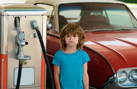 Photo for Kid boy at the gas station. Waiting for fuel. Kid fueling retro car at gas station. Refuel fill up with petrol gasoline. Petrol industry and service price and oil crisis concept - Royalty Free Image