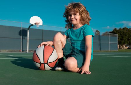 Foto de Kids little boy playing basketball. Child sport activity. Smiling boy plays ball - Imagen libre de derechos