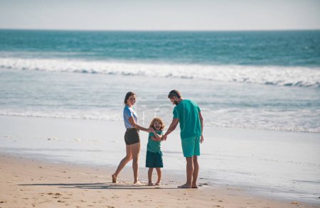 Foto de Feliz joven familia correr y saltar en la playa de verano. Niño con padres al aire libre. Concepto de infancia y crianza - Imagen libre de derechos