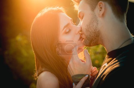 Téléchargez les photos : Embrasser un couple amoureux. Amoureux sexy embrasser en plein air au coucher du soleil. Sensuelle Les jeunes - en image libre de droit