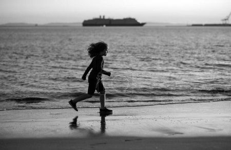 Photo for Kid running on beach. Happy child run in sea on summer vacation. Summer vacation with child - Royalty Free Image