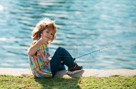 Foto de Feliz infancia. Niño pescando en el lago. Joven pescador. Chico con spinner en el río. Retrato de niño emocionado pescando. Chico en embarcadero con varilla. Concepto de pesca - Imagen libre de derechos