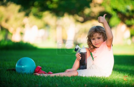 Foto de Niños deporte al aire libre. Agua potable en el parque. Fitness infantil, salud, ejercicios - Imagen libre de derechos