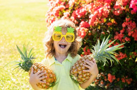 Photo for Child wearing funny sunglasses with pineapple. Kid with tropical fruit. Exotic vacation. Fruit for children. Summer kids holiday - Royalty Free Image