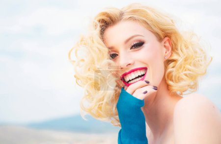Téléchargez les photos : Gros plan portrait d'une jolie femme souriante caucasienne blonde isolée sur blanc. Lèvres rouges, sourire aux dents. La tête et les épaules regardant la caméra. Maquillage mode - en image libre de droit