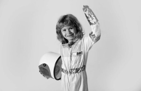 Téléchargez les photos : Enfant garçon jouant astronaute tenant un casque. Petit astronaute heureux - en image libre de droit