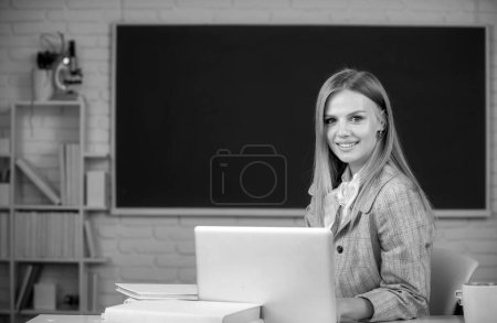 Téléchargez les photos : Portrait d'une étudiante qui étudie à l'université, assise à table et qui écrit sur un cahier à l'école ou à l'université - en image libre de droit