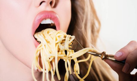 Close up sexy lips with noodles pasta. Female mouth eat spaghetti