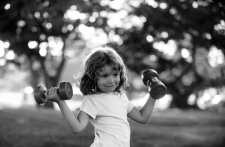 Foto de Los niños hacen ejercicio deportivo en el parque. Niños estilo de vida saludable. Deporte niño con músculos fuertes - Imagen libre de derechos