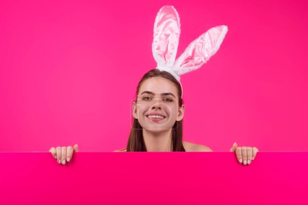 Photo for Portrait of lovely, romantic young woman in rabbit ears celebrating easter holiday, studio background. Holidays party concept. Cheerful girl celebrating Easter in rabbit ears, holding painted eggs - Royalty Free Image