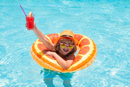 Photo for Child in sunglasses and summer hat drink summer cocktail and floating in pool. Cute little boy in pool on summer day with tropical cocktail. Outdoor summer activity for children - Royalty Free Image