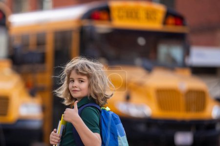 Téléchargez les photos : Un écolier monte dans le bus scolaire. L'école américaine. Je retourne à l'école. Enfant de l'école primaire. Des enfants heureux prêts à étudier. Concept éducatif - en image libre de droit