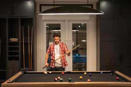 Photo for Man Playing the billiards. Man play american billiard in Billiard room. Snooker Player. Young professional man playing billiards in the billiard club - Royalty Free Image